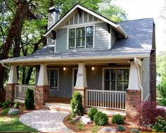 a gray and white house in the woods