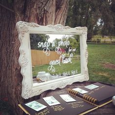 a mirror sitting on top of a wooden table next to a tree