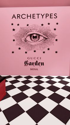 a pink room with black and white checkered flooring, an all seeing eye on the wall