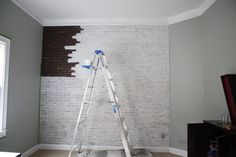 a ladder leaning against a brick wall in a room with white paint on the walls