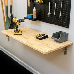 a work bench with tools on it in front of a wall mounted tool rack and pegboard