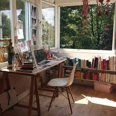 a desk with a laptop computer sitting on top of it next to a book shelf filled with books