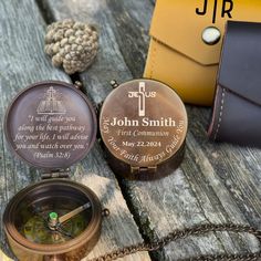 two personalized compasss sitting on top of a wooden table next to a wallet