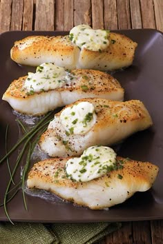 three fish fillets on a brown plate with green garnishes and herbs