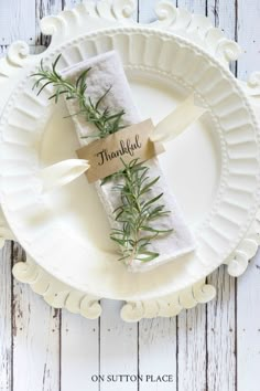 a white plate topped with napkins covered in greenery