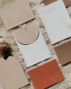 wedding stationery and envelopes laid out on a white furnishing with flowers