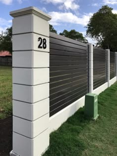 a white and gray fence with the number 28 on it in front of some grass