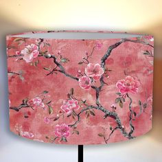 a lamp shade with pink flowers painted on it