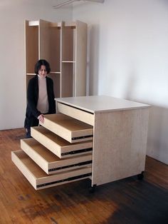 a woman standing in front of a set of stairs made out of plywood planks