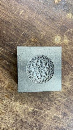 a wooden table with a metal stamp on it