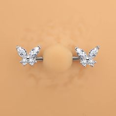 an image of two diamond studs on top of each other in front of a beige background