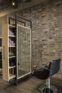 a salon chair sitting in front of a brick wall with shelves on each side and an open door to the other side