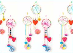 an assortment of colorful handmade items hanging on a white wall in the shape of hearts