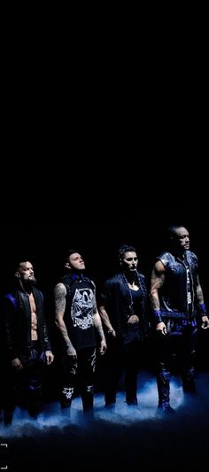 five men standing in front of a black background