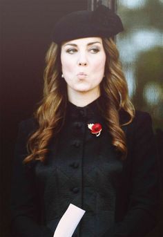 a woman with long hair wearing a black coat and hat