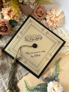 a graduation cap sitting on top of a table next to flowers