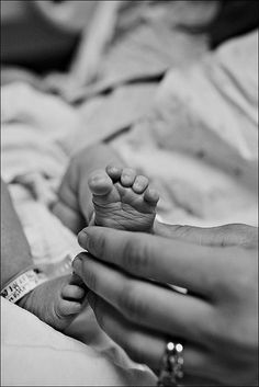 a person holding a baby's foot in their hands