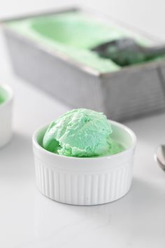 a white bowl filled with green ice cream