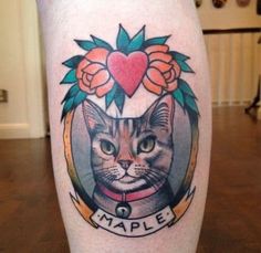 a close up of a person's leg with a cat on it and flowers