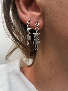 This set includes  1 MOON MAN earring 1 STAR MAN earring  Fallen from the galaxies above--these lively little figures have quite the personality! A pair of storytellers weaving tales of how we're all woven from stardust. Handcrafted with a galactic design these earrings capture the magic of the cosmos. SOLID STERLING SILVER HANDCRAFTED WITH LOVE Man Earring, Little Figures, Moon Man, The Cosmos, Men Earrings