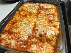 a casserole dish with meat and cheese in it sitting on a stove top