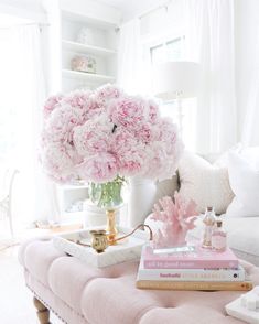 a living room filled with lots of furniture and flowers on top of a coffee table