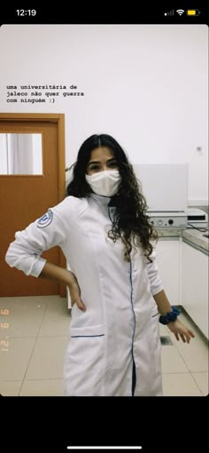 a woman in a white lab coat and mask standing with her hands on her hips