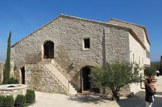 an old stone building with steps leading up to the front door and two people standing outside