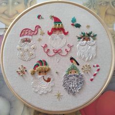 a close up of a embroidery on a hoop with santa and other christmas related items