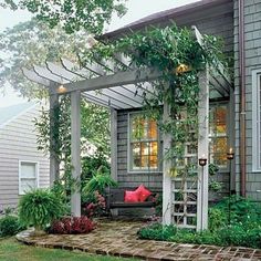 a house with a porch covered in plants and flowers