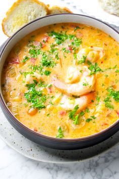 a bowl of soup on a plate with bread