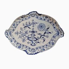 an ornate blue and white plate with flowers on the rim, against a white background