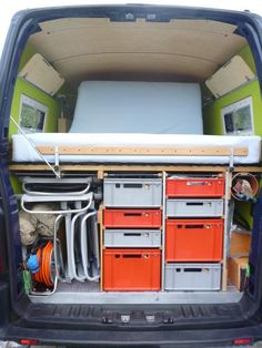 the back end of a van with many drawers and other items in it's trunk