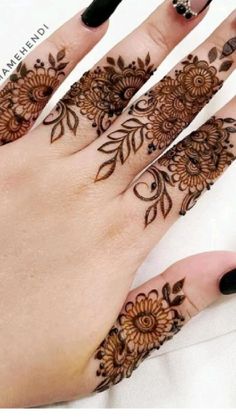 a woman's hand with henna tattoos on it