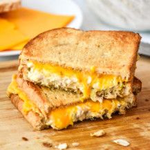 a grilled cheese sandwich cut in half on a cutting board