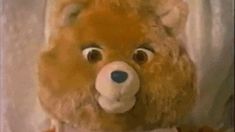 a brown teddy bear sitting in front of a white curtain with the words youtube on it