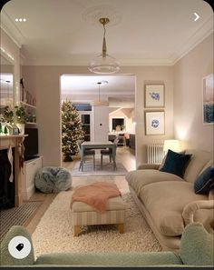 a living room filled with furniture and a christmas tree in the corner on the wall