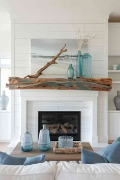 a living room filled with furniture and a fire place covered in blue glass vases