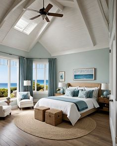 a bedroom with a large bed and two chairs in front of windows overlooking the ocean