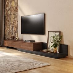 a flat screen tv sitting on top of a wooden entertainment center next to a window