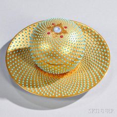 a yellow hat with polka dots on it sitting on top of a white tablecloth