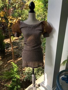 a mannequin wearing a brown dress on display