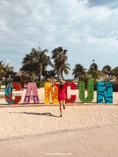 a woman is running in front of the sign that says cancuano on the beach