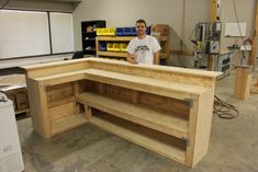 a man standing in front of a work bench made out of plywood planks