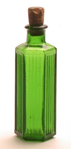 a green glass bottle with a cork top