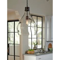 a glass light fixture hanging from the ceiling in a kitchen