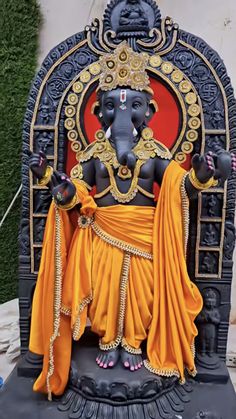 an elephant statue sitting on top of a black stand next to a red and white wall