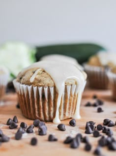 chocolate chip muffins with icing drizzled over them on a cutting board