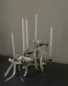 a group of white candles with ribbons around them