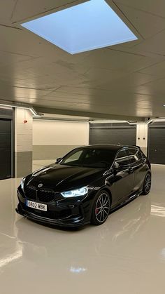 a black car is parked in an empty garage